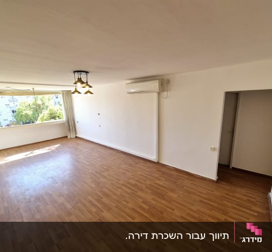 חדר ריק עם רצפת עץ, חלון גדול ומזגן על הקיר